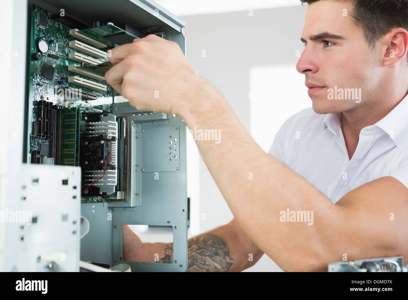 Handsome frowning computer engineer working at open computer Stock Photo