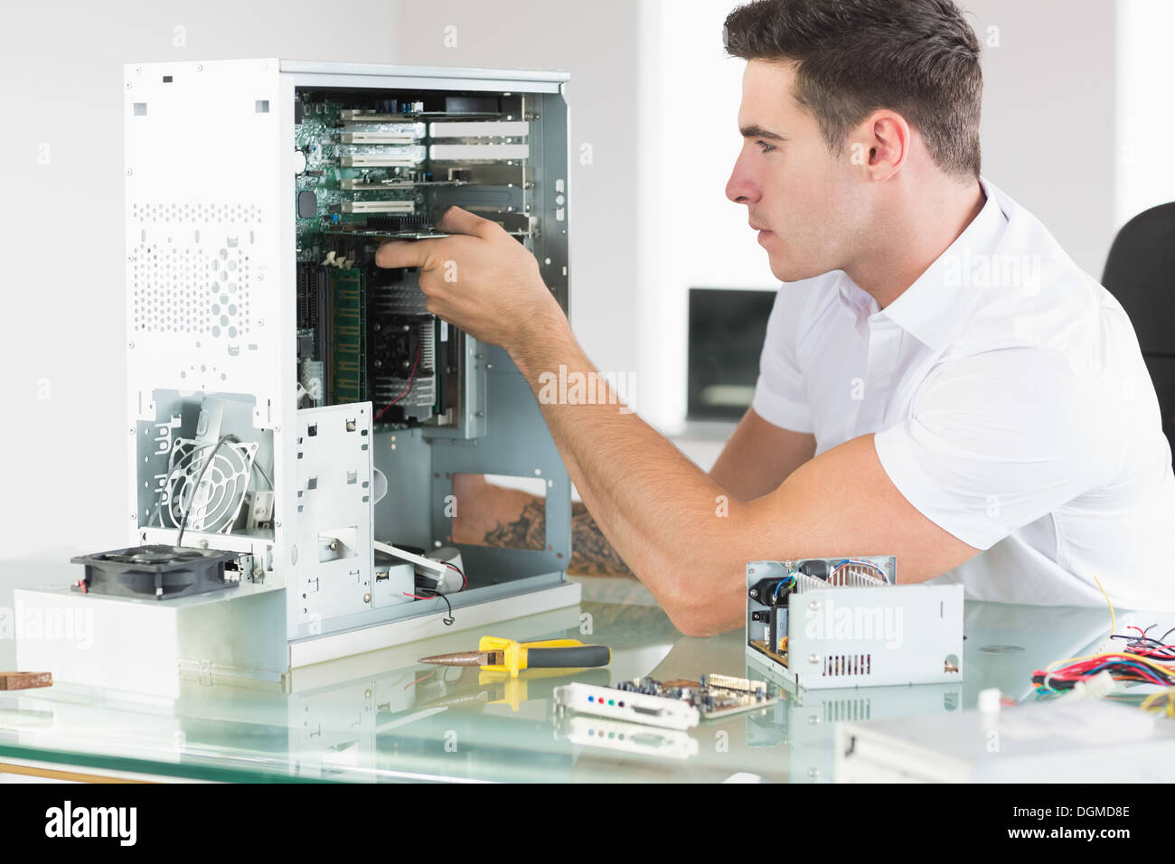 Handsome unsmiling computer engineer working at open computer Stock Photo