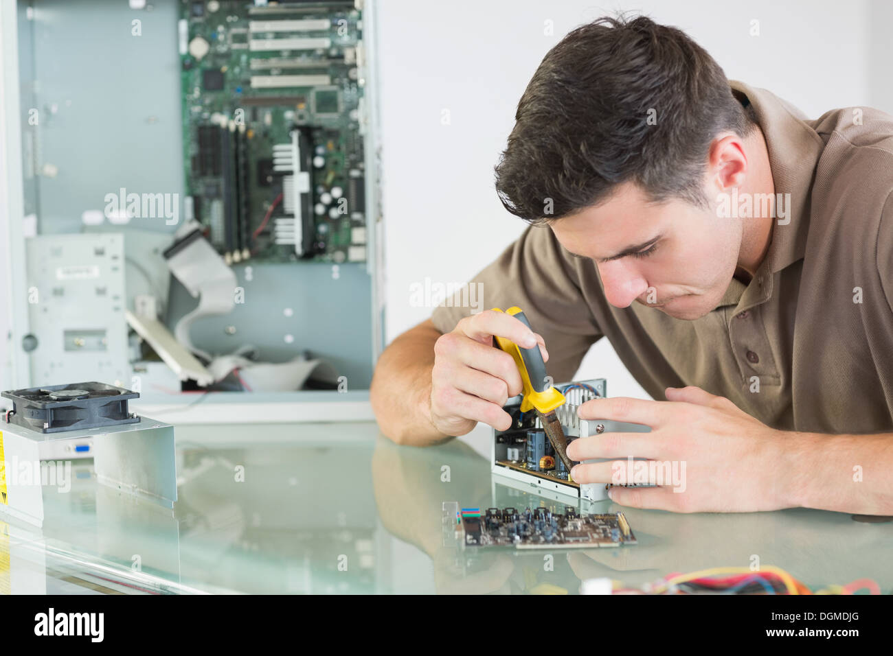 Handsome serious computer engineer repairing hardware with pliers Stock