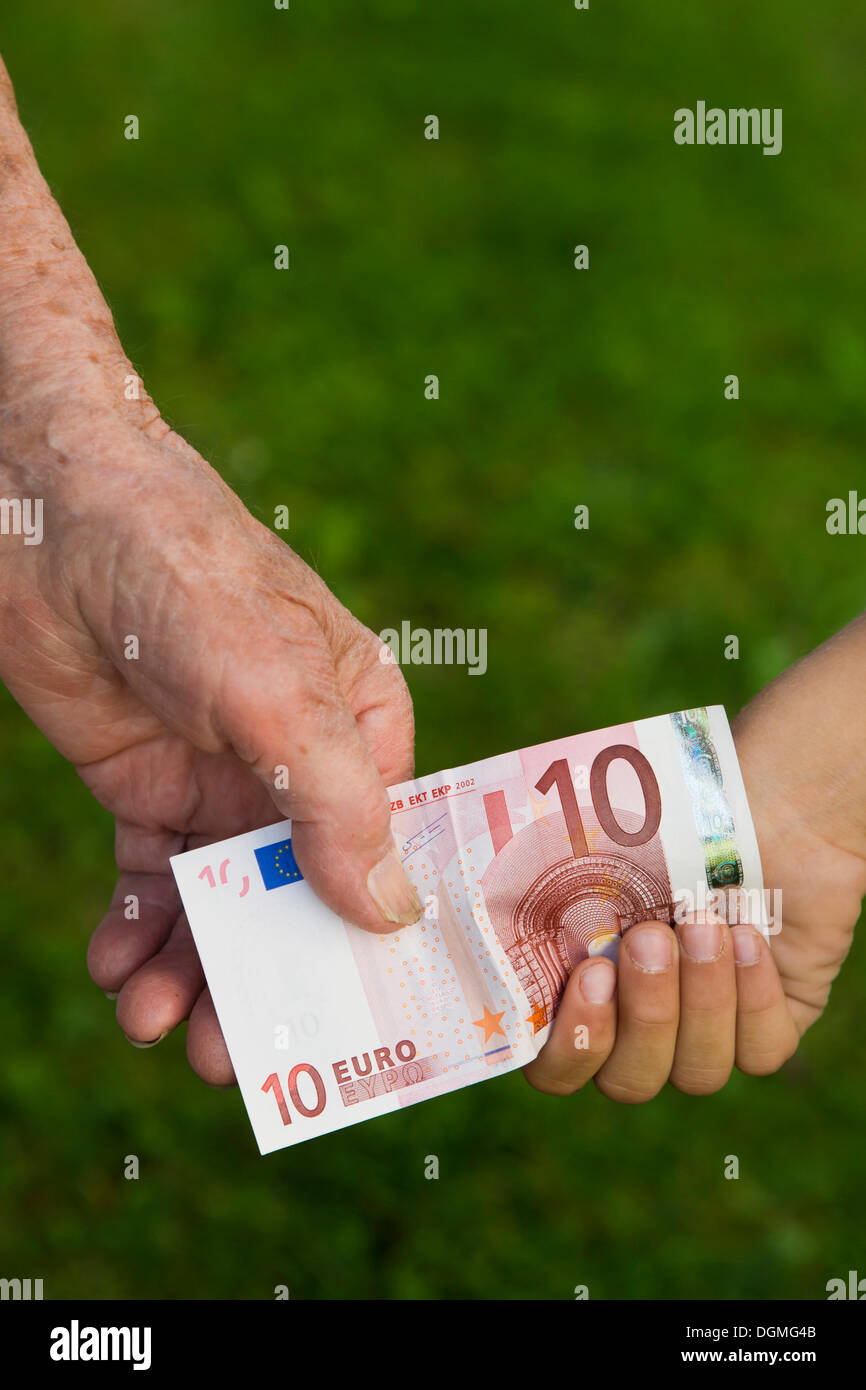 Elderly woman and a child holding a 10-euro banknote Stock Photo
