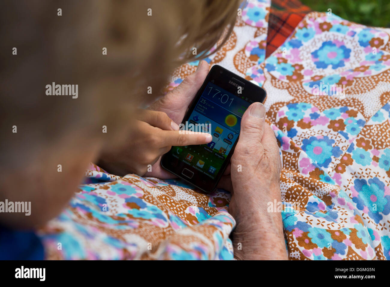 Child showing an elderly woman something on a smartphone Stock Photo