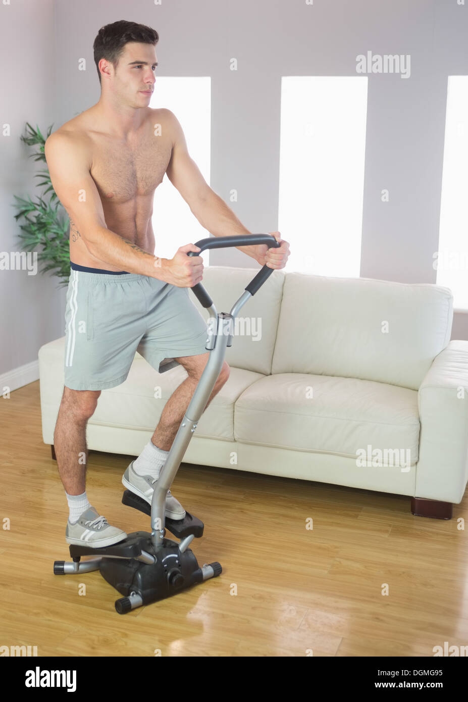 Serious handsome man training on stair climber Stock Photo