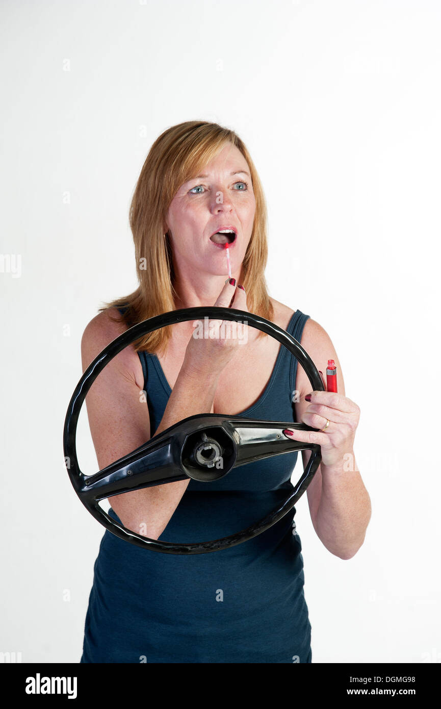 Female motorist applying make up at the steering wheel and not wearing