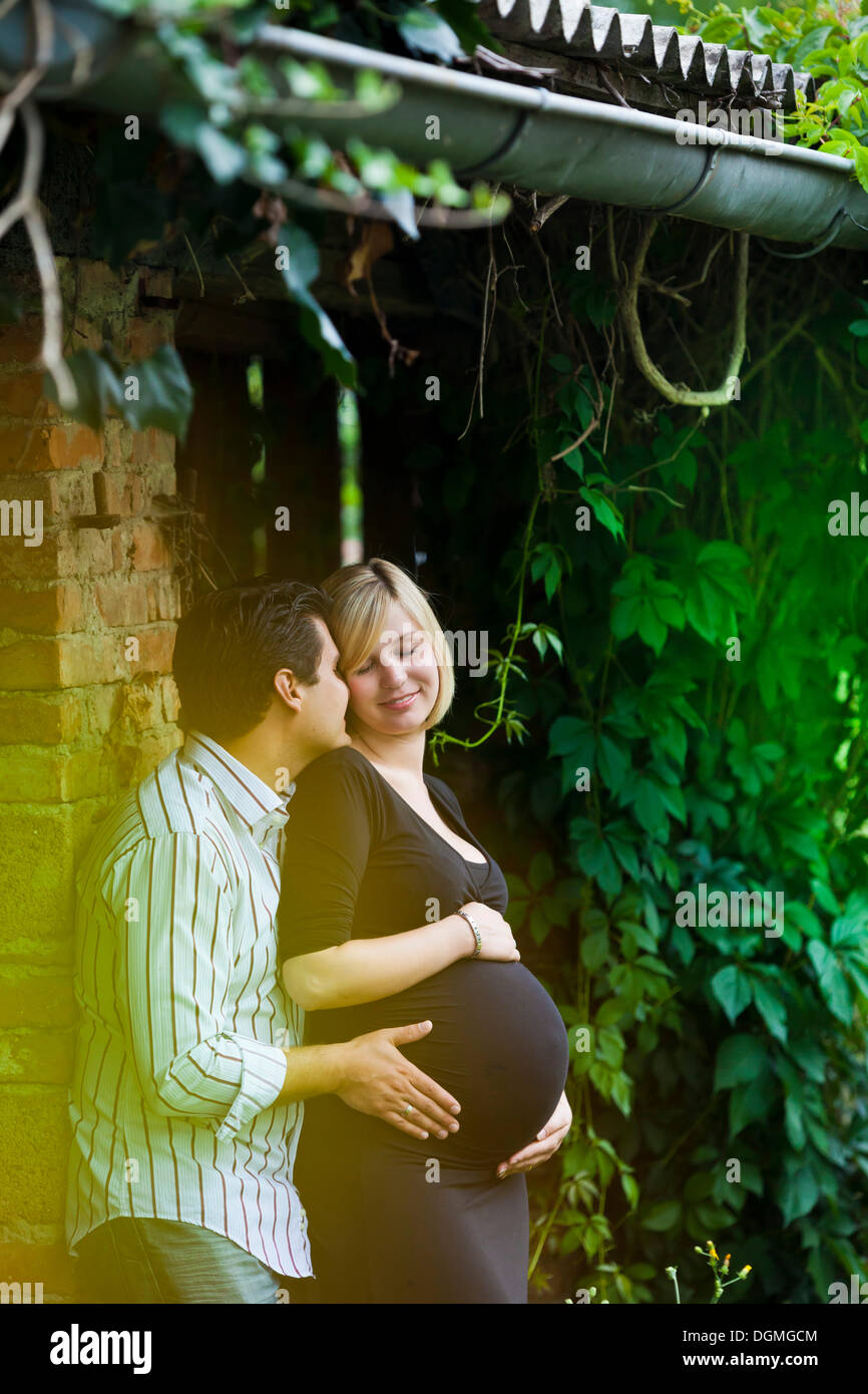 Man and a pregnant woman holding their hands on her belly Stock Photo