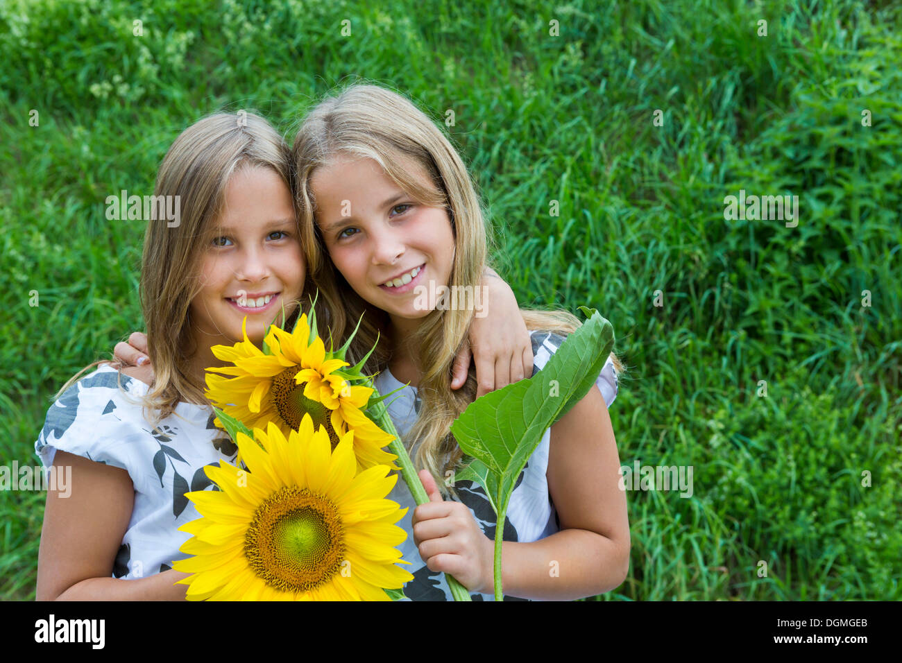 Twin girls, 9, with sunflowers Stock Photo