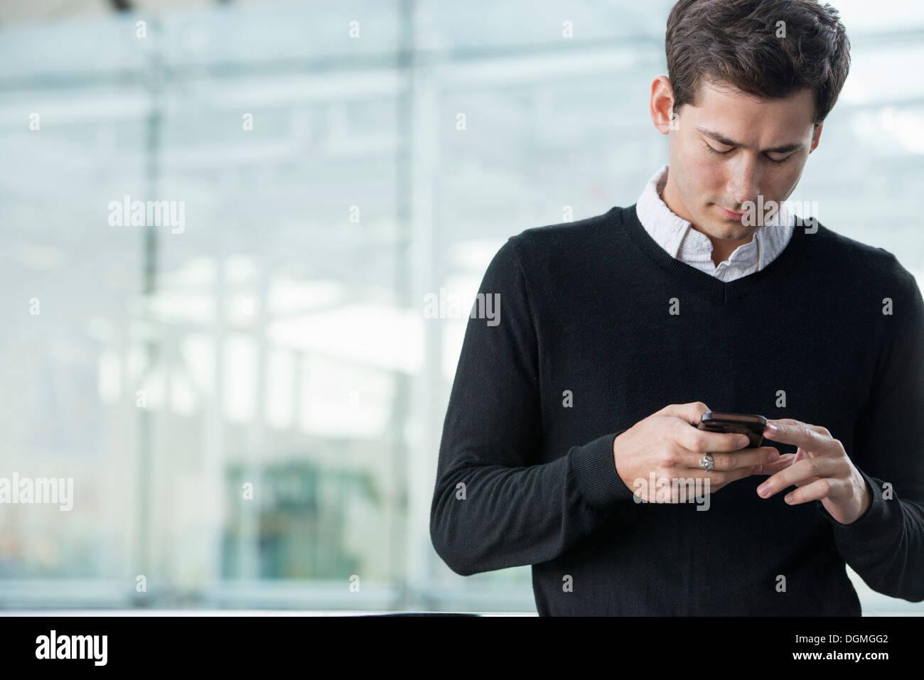 Summer in the city. Business people in casual clothes. A young man checking his smart phone. Stock Photo