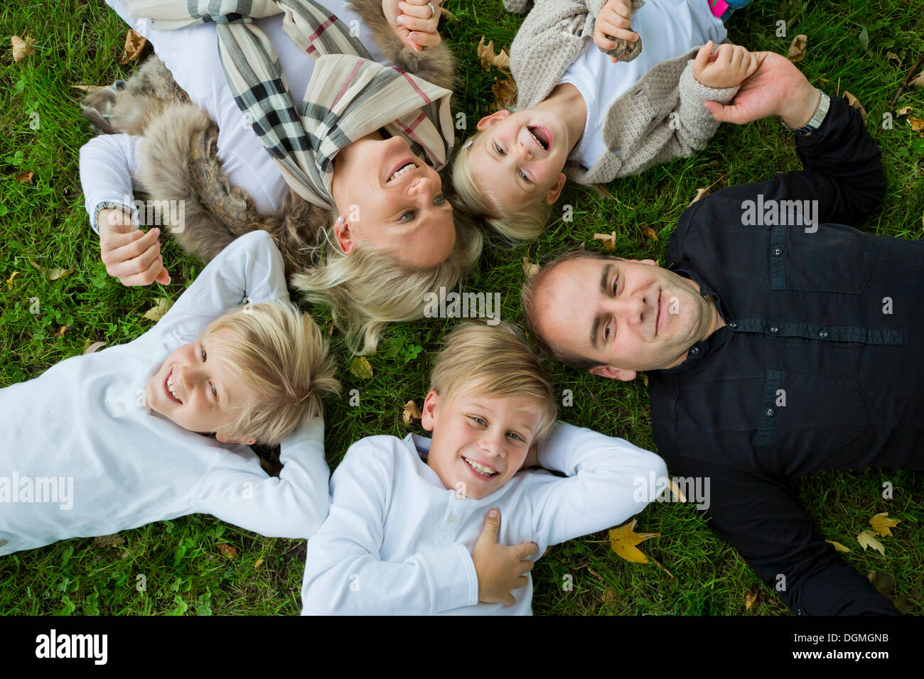 Family with three children lying on the grass Stock Photo