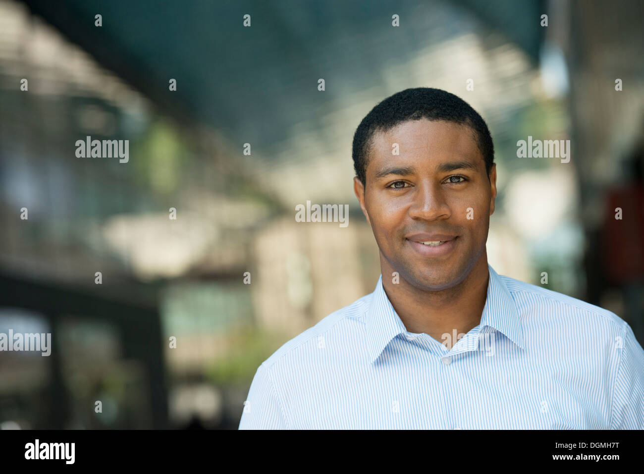 Business people on the move. A man in an open necked shirt smiling. Stock Photo