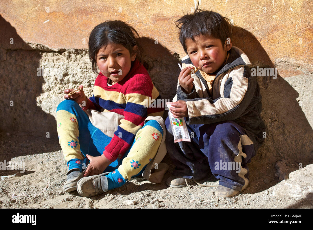 Quechua children eating biscuits in Quetena Chico, Atacama Desert, Altiplano, southern Bolivia, South America Stock Photo