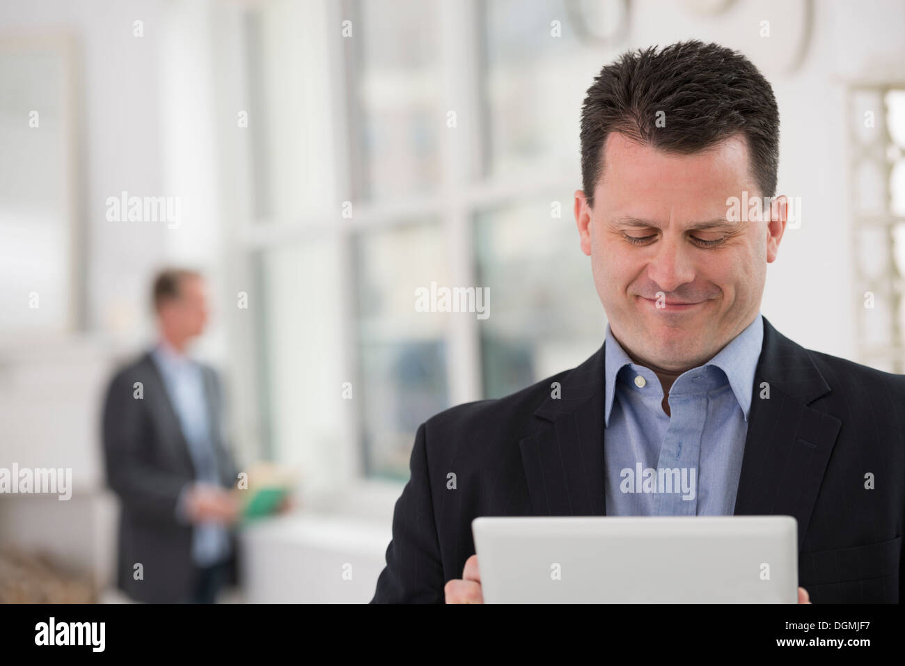 Business people. A man in a dark suit using a digital table. Stock Photo