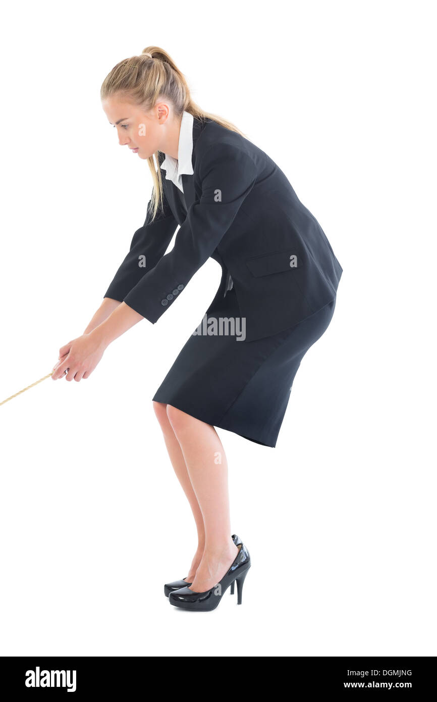 Concentrating young businesswoman pulling a rope Stock Photo