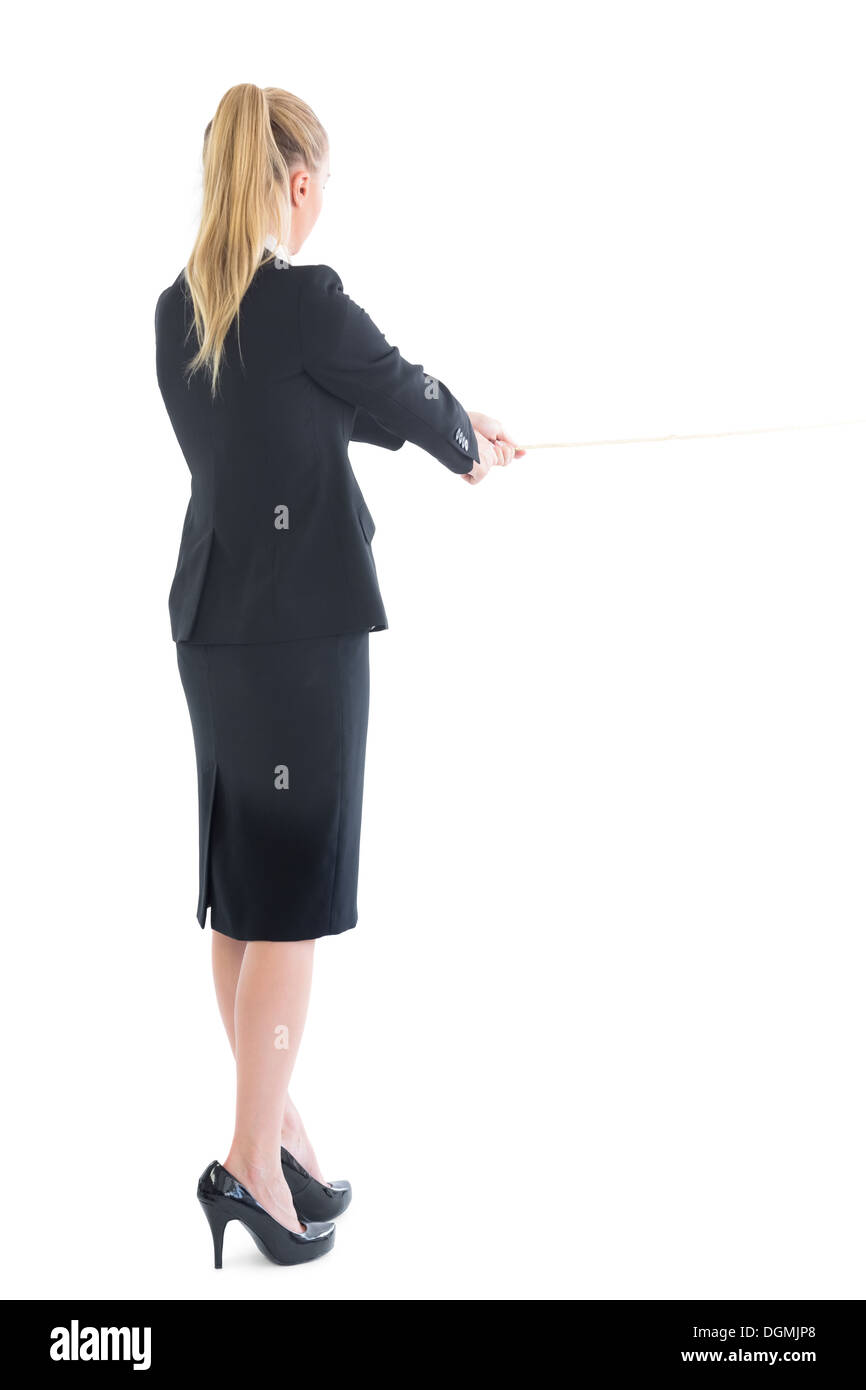 Rear view of standing business woman pulling a rope Stock Photo