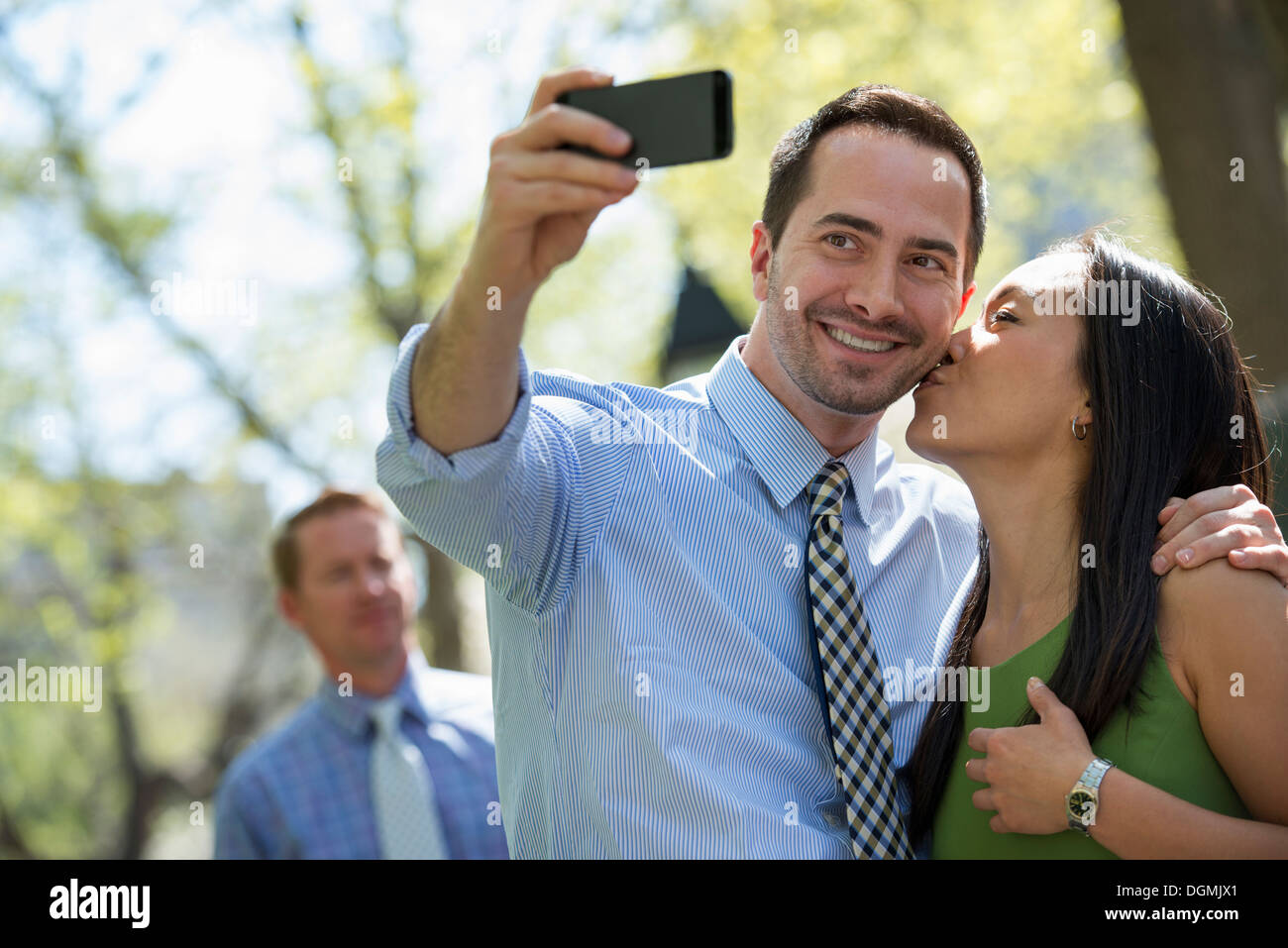 A businesswoman and two businessmen outdoors in the city. Stock Photo