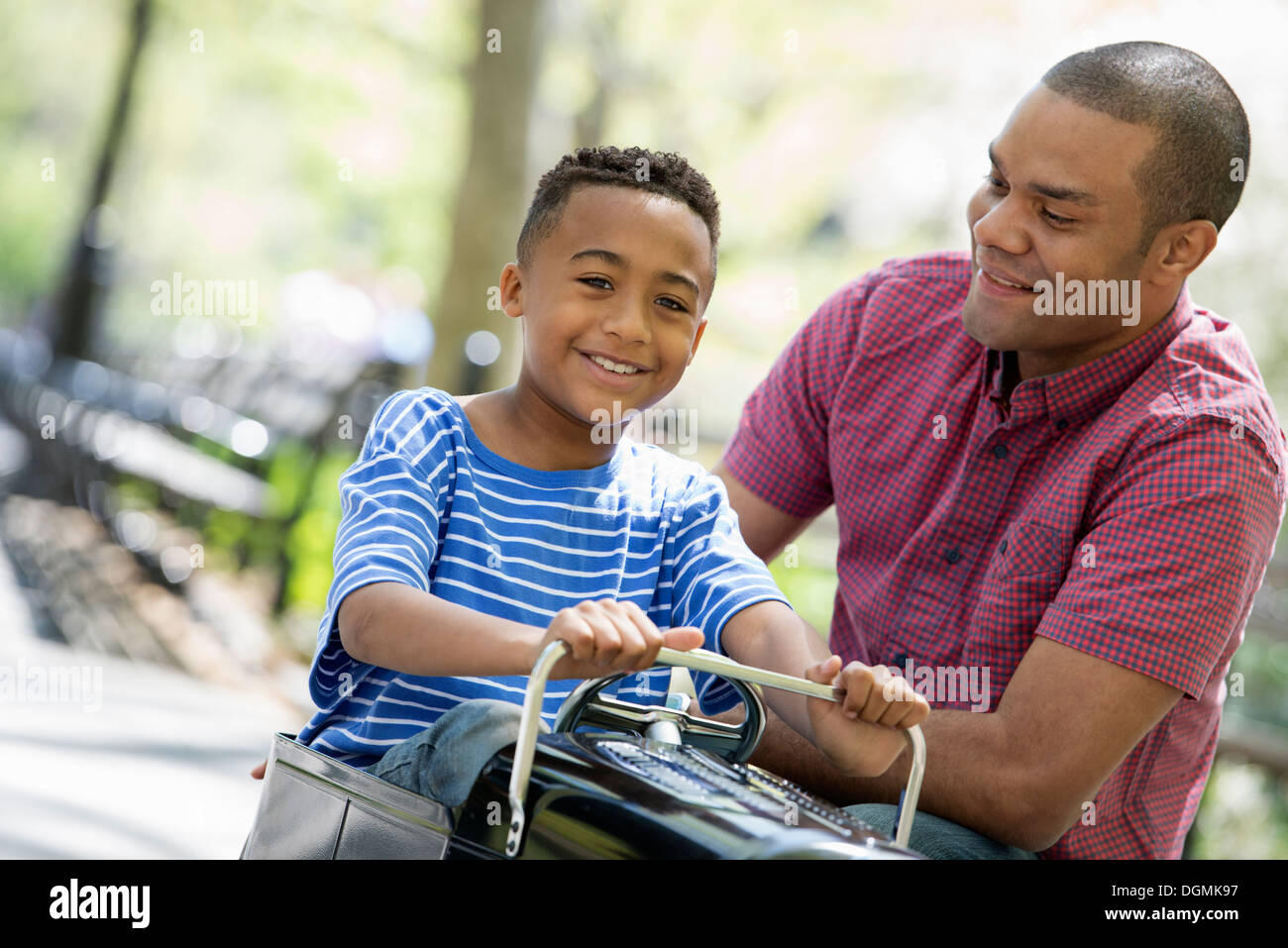 A boy riding an old fashioned toy peddle car. Stock Photo