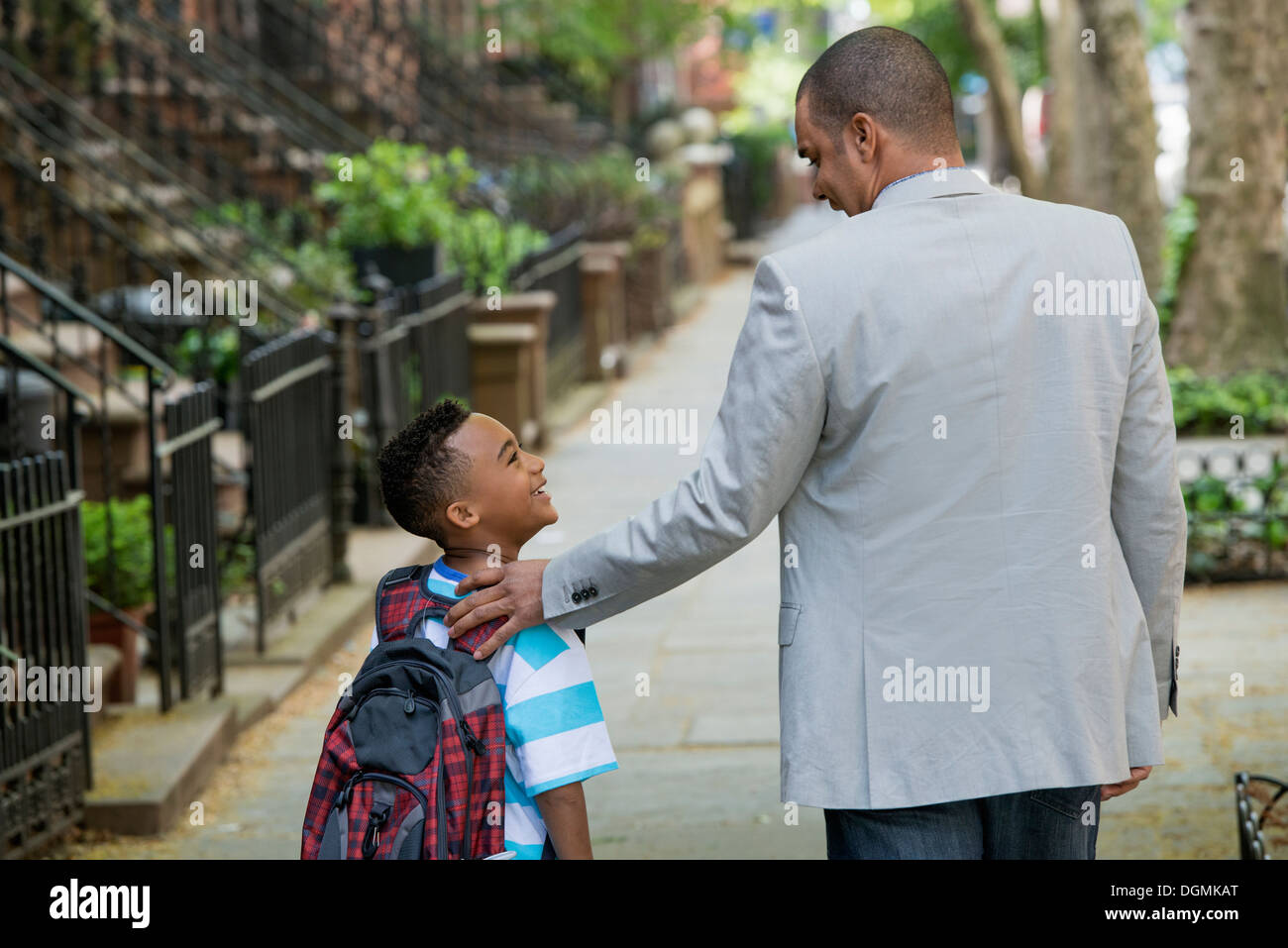 An adult and a child, a father and son, walking together on the street in the city. Stock Photo