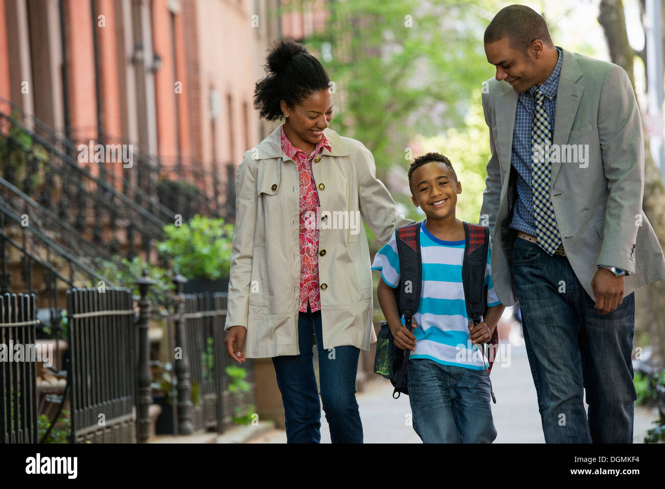 A family outdoors in the city. Two parents and a young boy walking together. Stock Photo