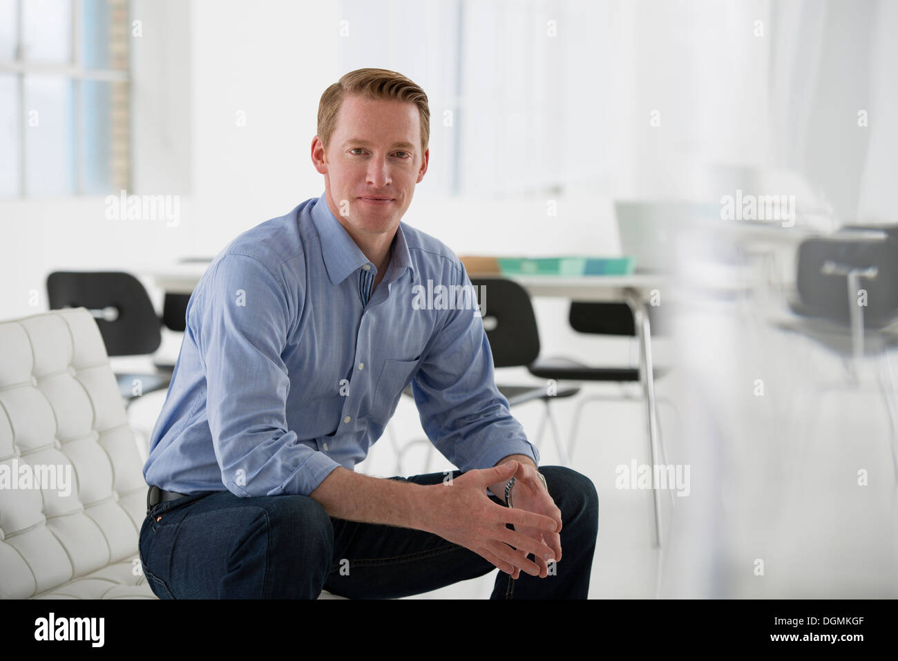 Business. A man in a blue shirt sitting down. Stock Photo