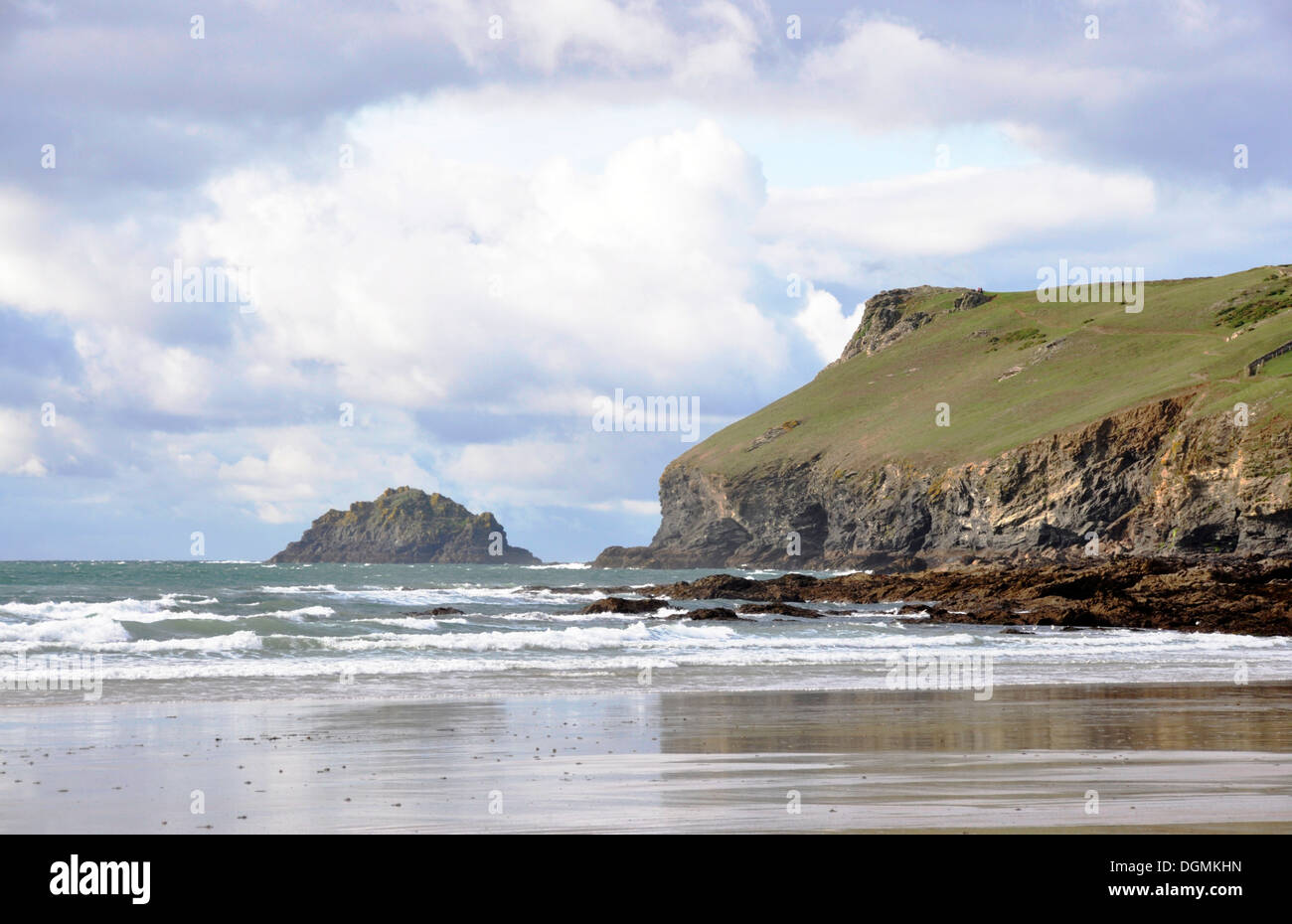 North Cornwall - Pentire Point - viewed from Polzeath beach - across breaking waves - steep cliffs - bright skyscape Stock Photo