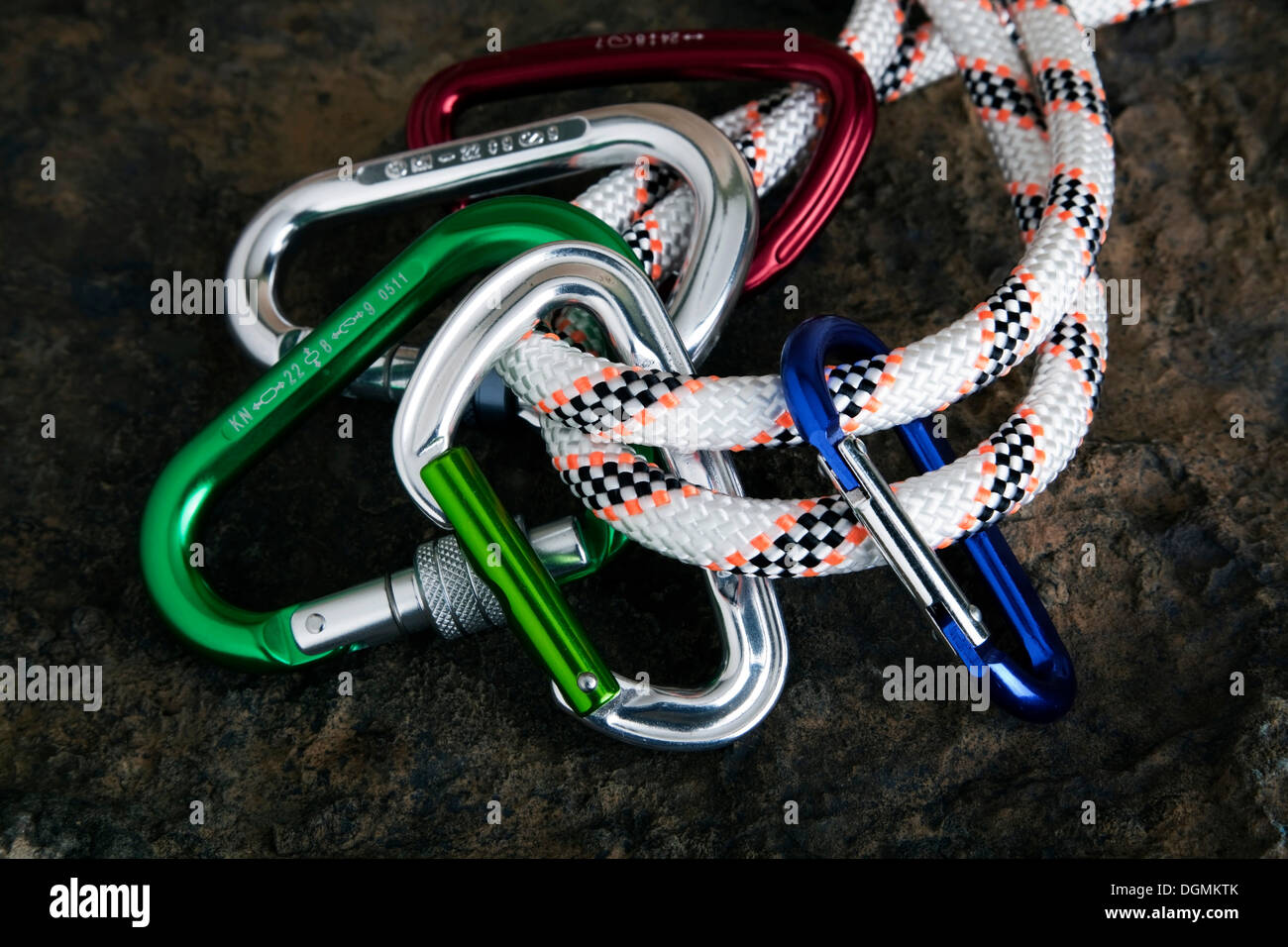 Five carabiner on rope on a stone surface Stock Photo