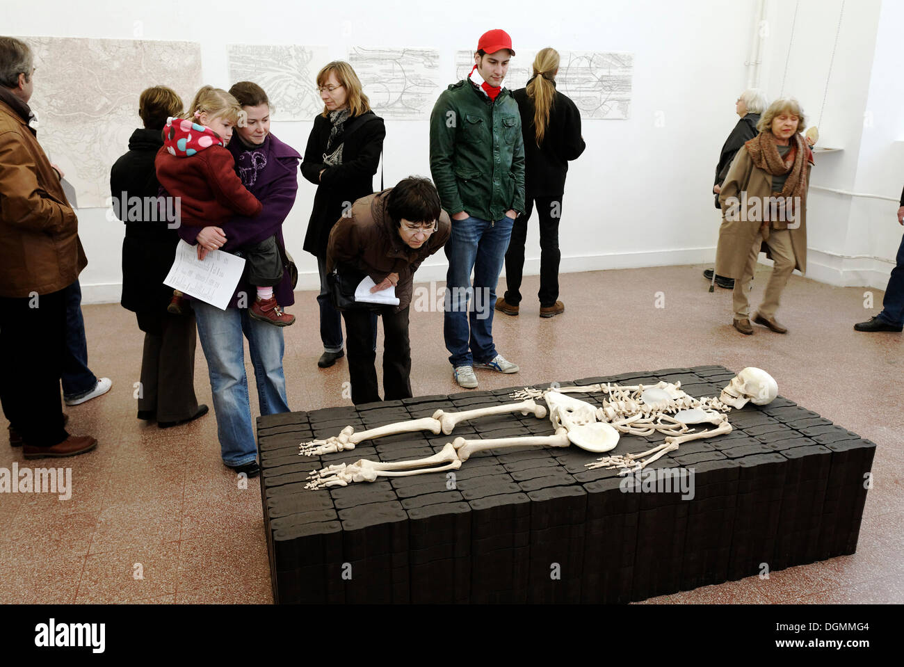 Visitors look at a sculpture, human skeleton lying on briquettes, tour Kunstakademie Art Academy in Duesseldorf Stock Photo