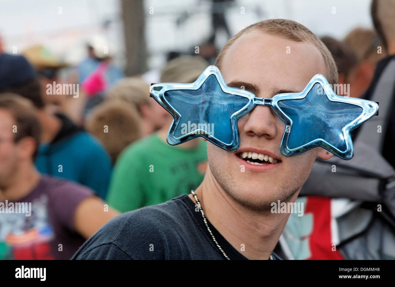 Young man wearing quirky sunglasses, Loveparade 2010, Duisburg, North Rhine-Westfalia Stock Photo