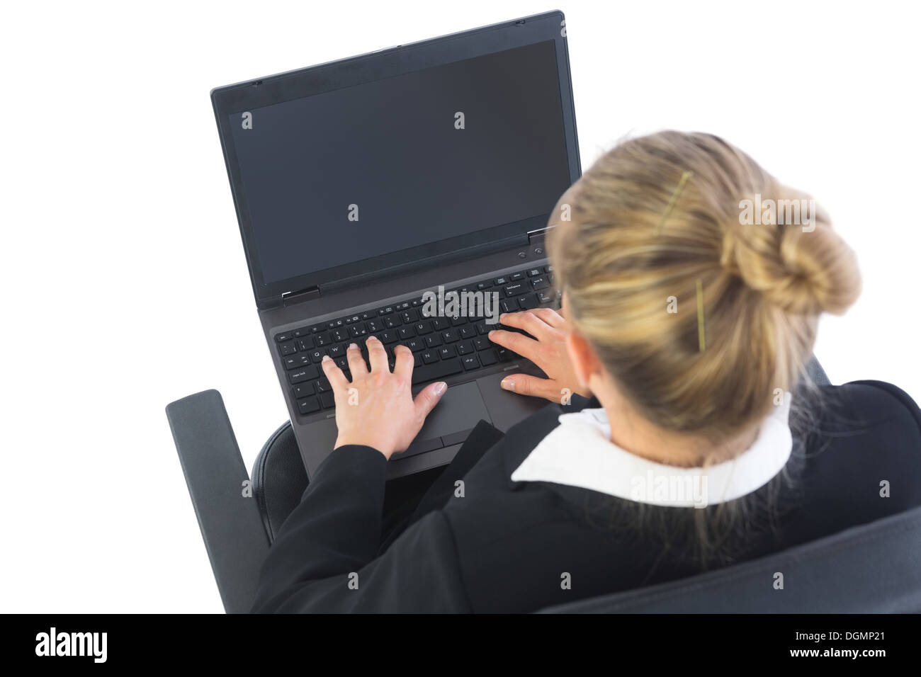 Rear view of businesswoman sitting in swivel chair using laptop Stock Photo