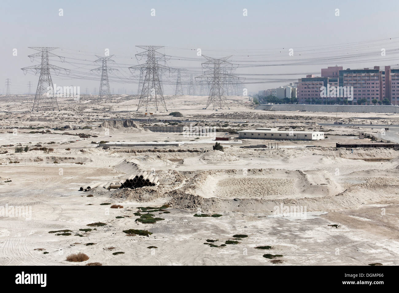 Barren land with electricity transmission pylons, urban development area, Nakheel Harbour, Dubai, United Arab Emirates Stock Photo