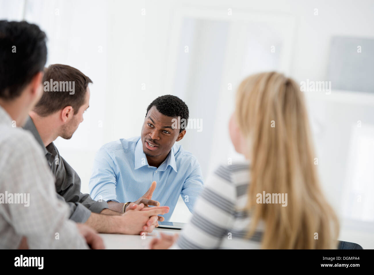 Office interior. A group of four people, One woman and three men. Stock Photo