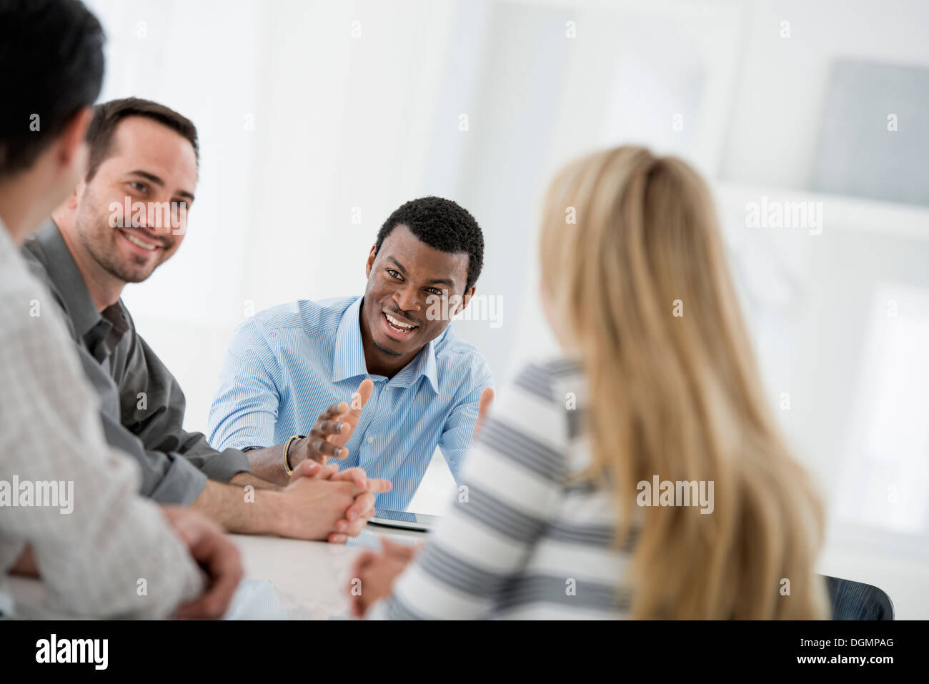 Office interior. A group of four people, One woman and three men. Stock Photo