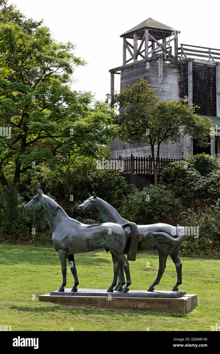 Two horses in a meadow, sculpture by Philip Hart, and a graduation tower, Grugapark, Essen, Ruhr area, North Rhine-Westphalia Stock Photo