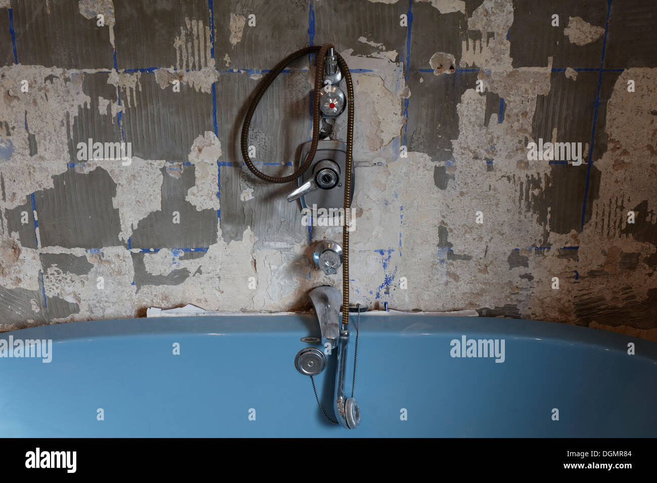 Rotted bathtub fittings above tub, removed tiles, old bathroom, old