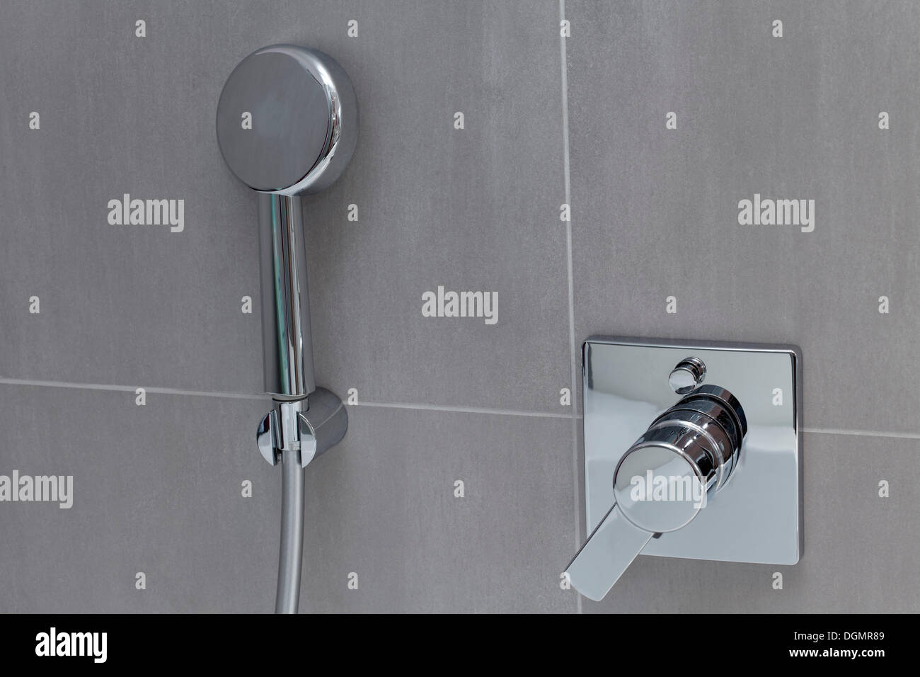 Modern shower head and bathroom fitting on tiled wall Stock Photo