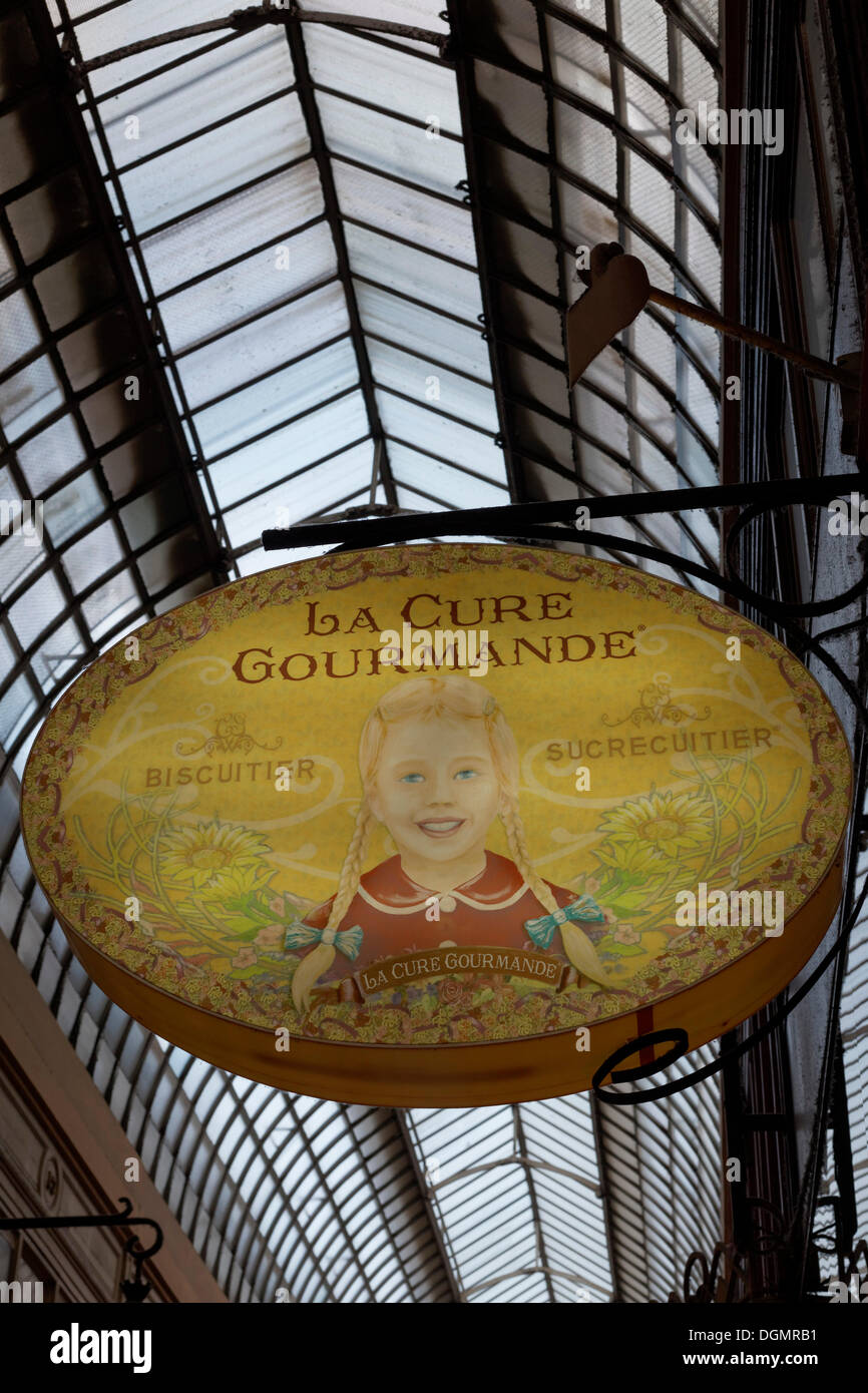 Shop sign with the image of a girl, La Cure Gourmande candy store, historic shopping arcade, Passage Jouffroy, Grands Boulevards Stock Photo