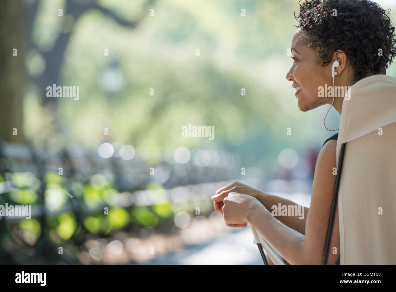 City life. A woman sitting in a camping chair in a city park. Stock Photo