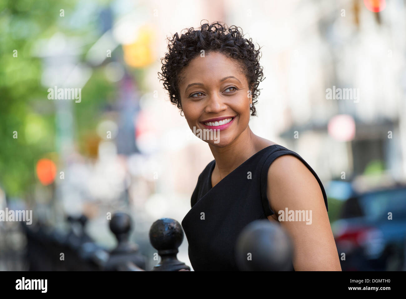 People on the move. A woman in a black dress on a city street. Stock Photo
