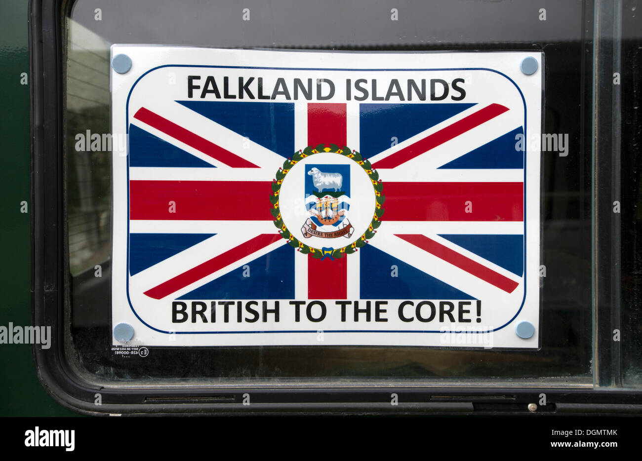 Sign 'Falkland Islands - British to the Core' with a coat of arms and the flag of the Falkland Islands, displayed in a car Stock Photo