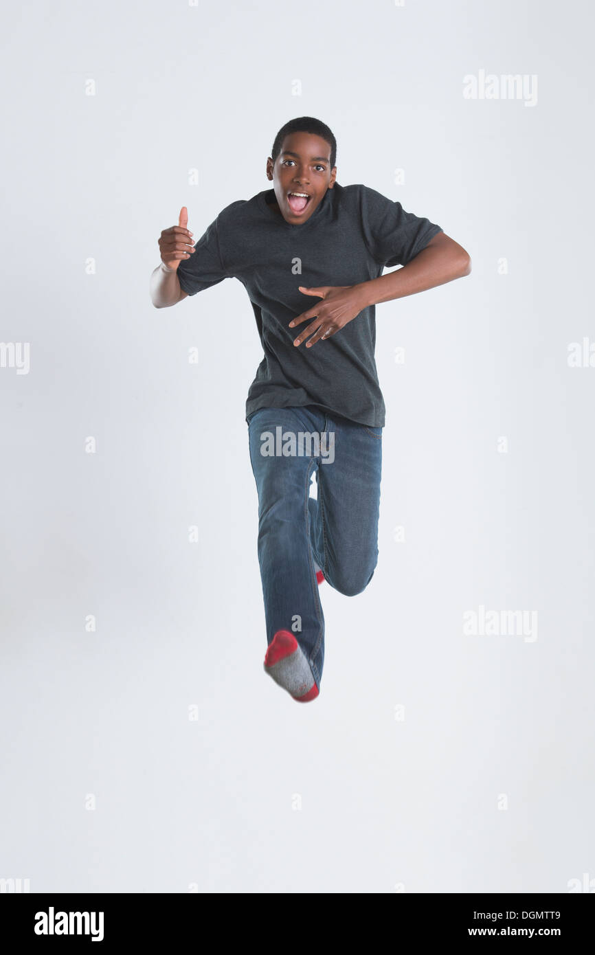 Studio Shot of teenage boy (14-15) jumping Stock Photo