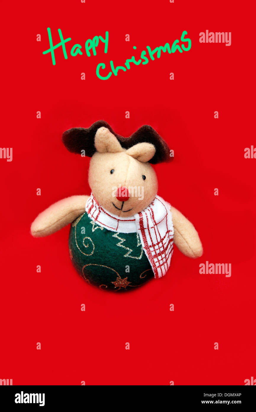 fun soft toy Rudolph the red nosed reindeer Christmas decoration on a red background Stock Photo