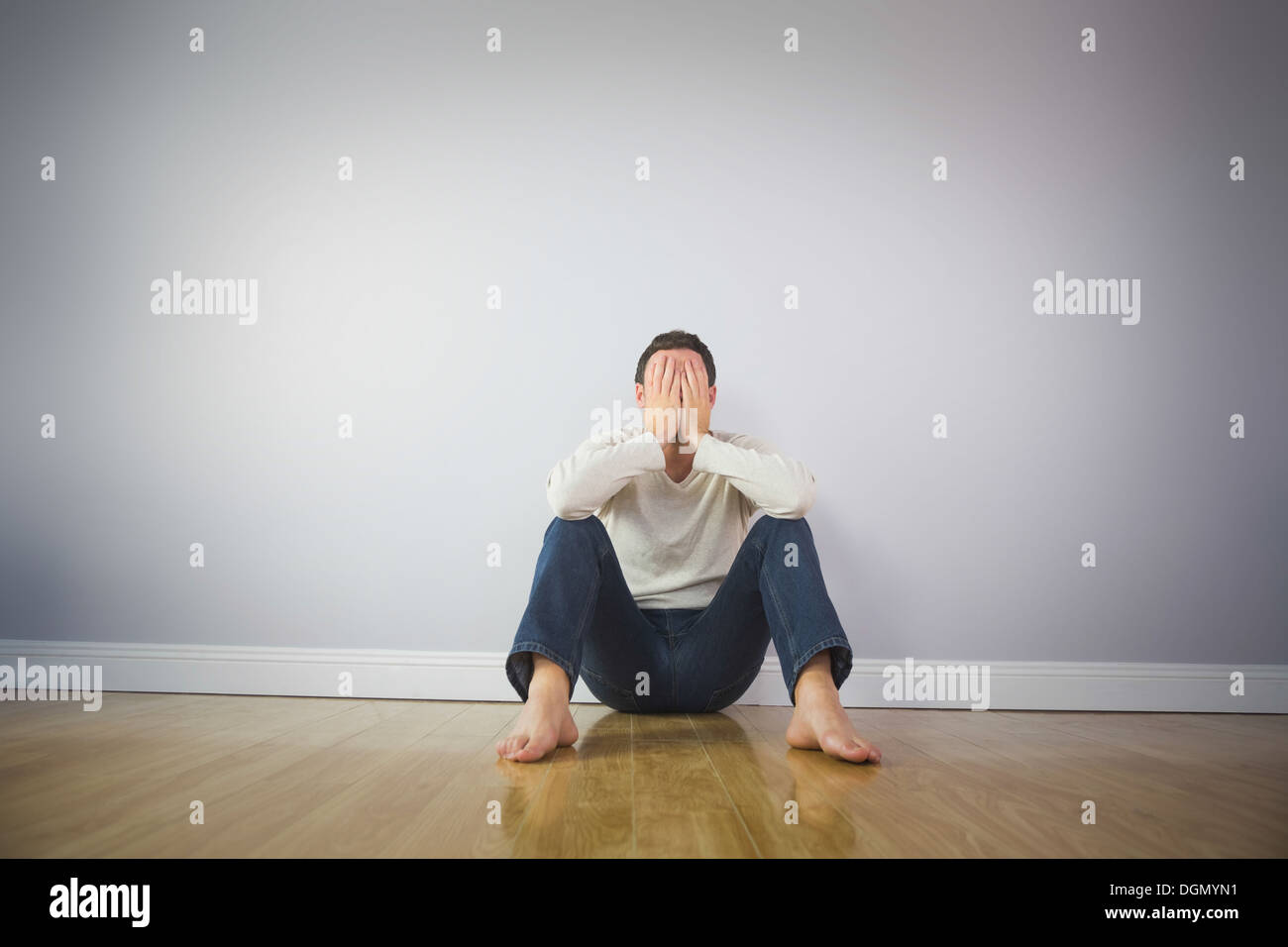 Casual sad man covering his face with hands Stock Photo