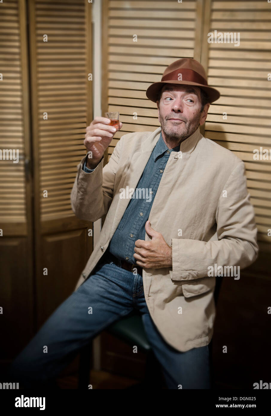 convivial man drinking from shot glass Stock Photo