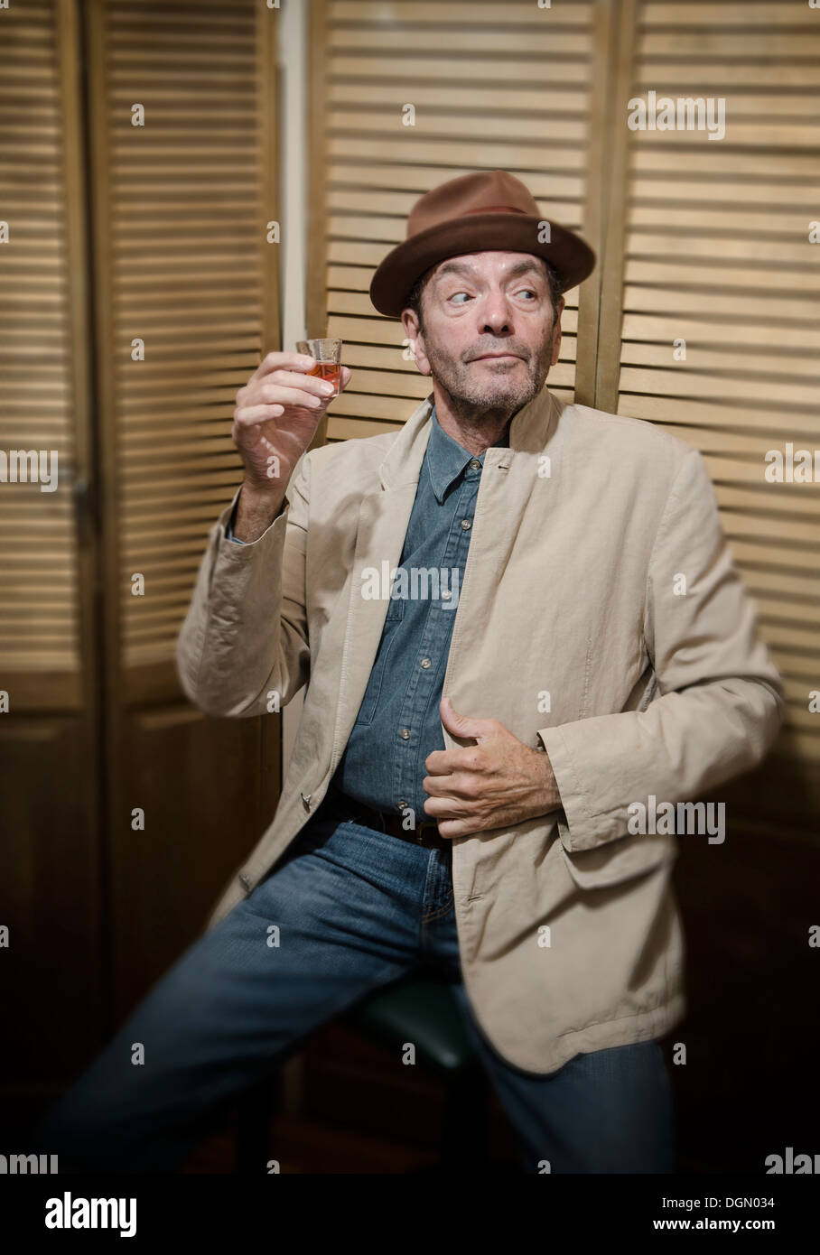 carefree man drinking from shot glass Stock Photo