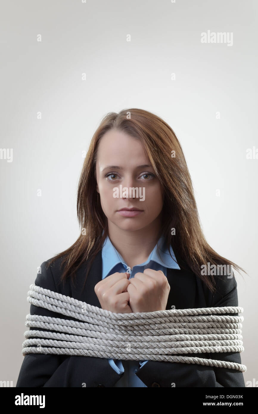 bound by rope businesswoman tied maybe for a corporate crime  Stock Photo