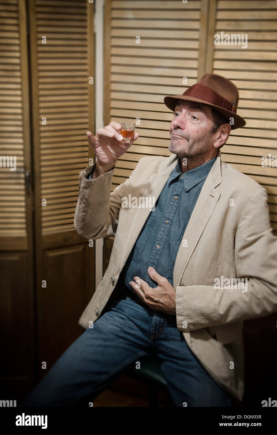 carefree man drinking from shot glass Stock Photo
