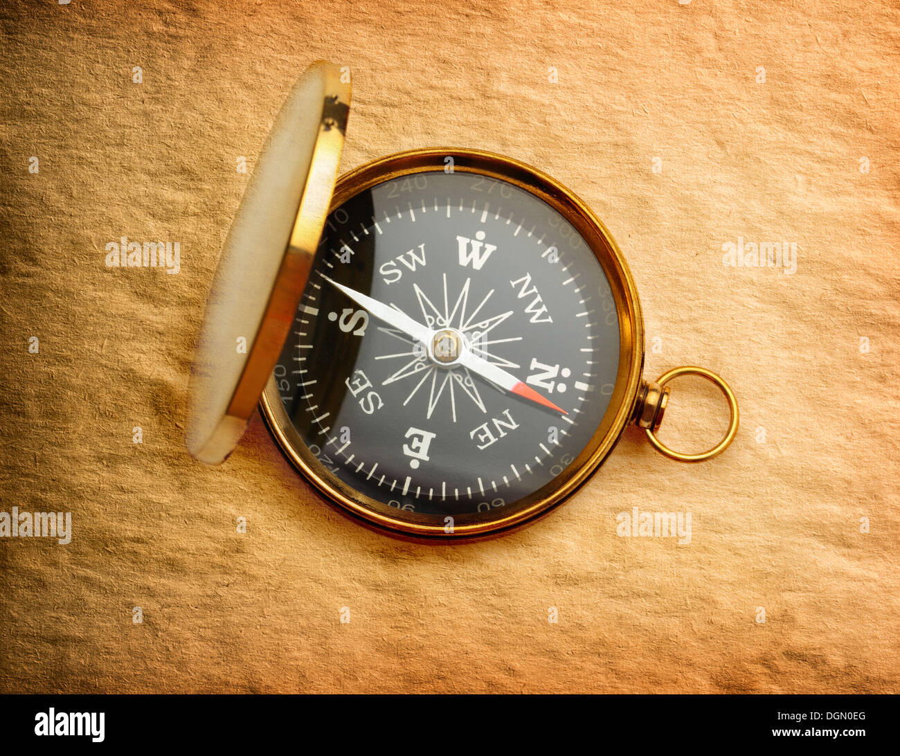 Single golden compass on paper background Stock Photo