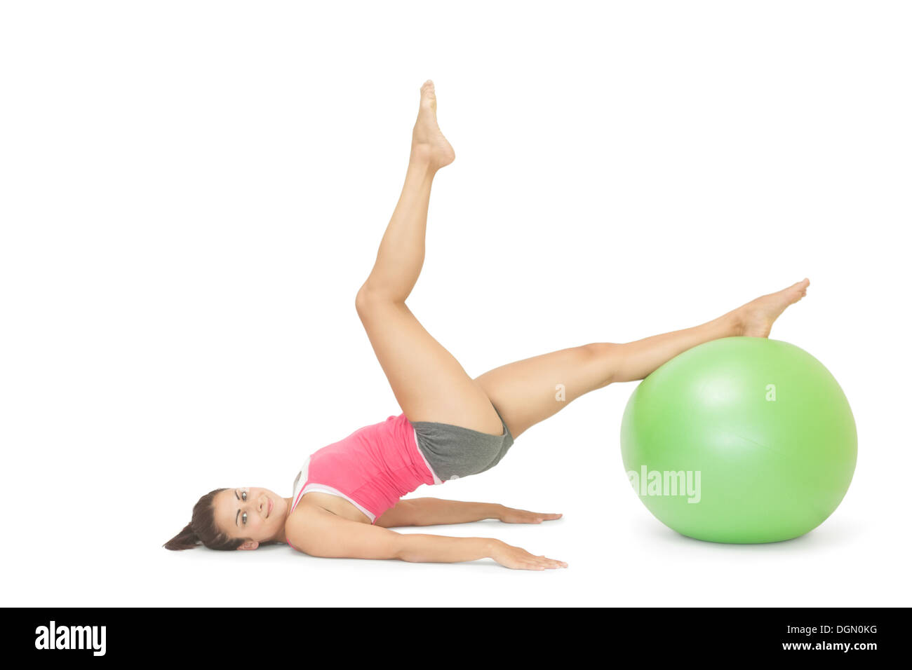 Smiling sporty brunette exercising with exercise ball Stock Photo
