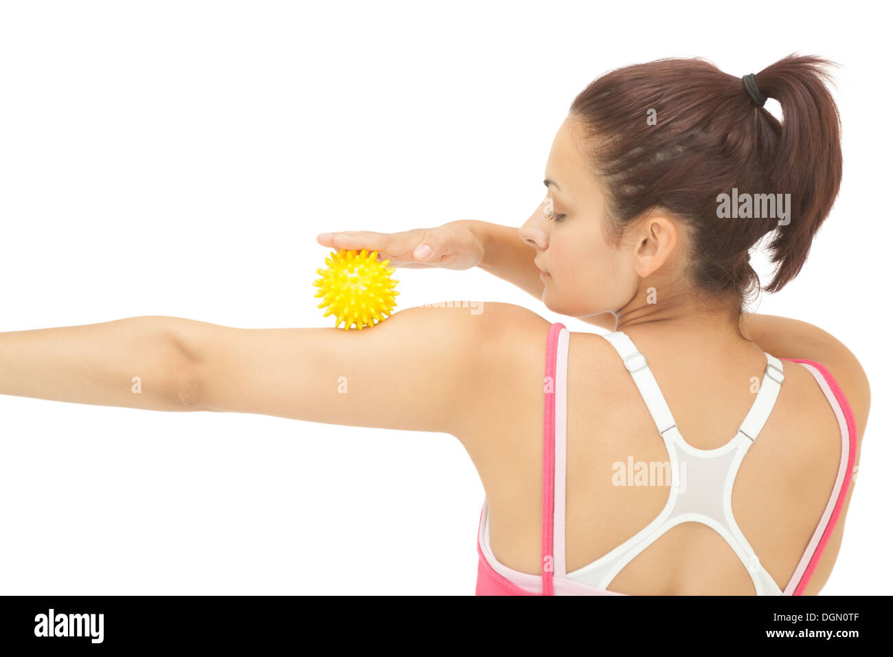 Rear view of sporty brunette touching arm with yellow massage ball Stock Photo