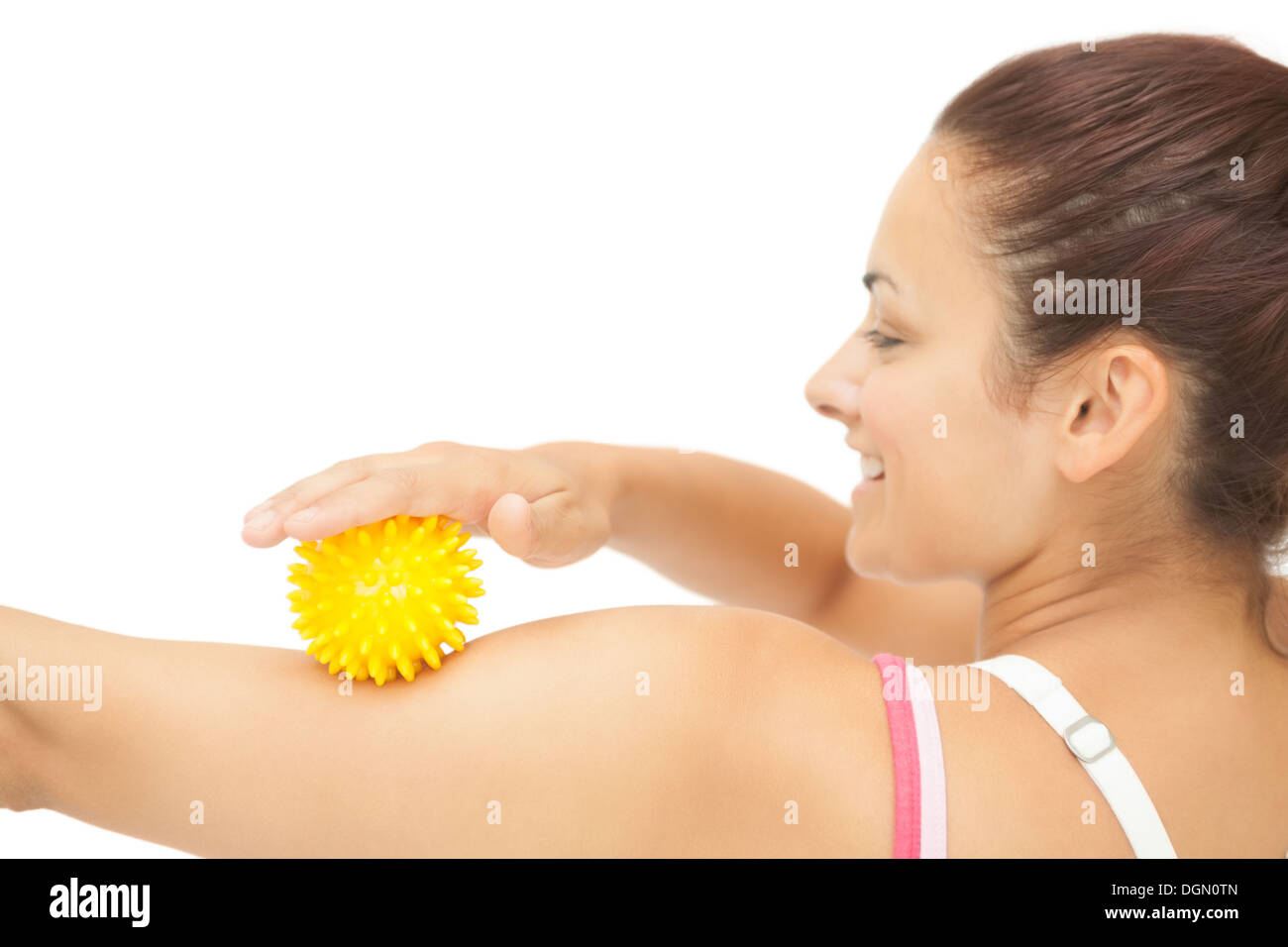 Cheerful sporty brunette touching arm with yellow massage ball Stock Photo