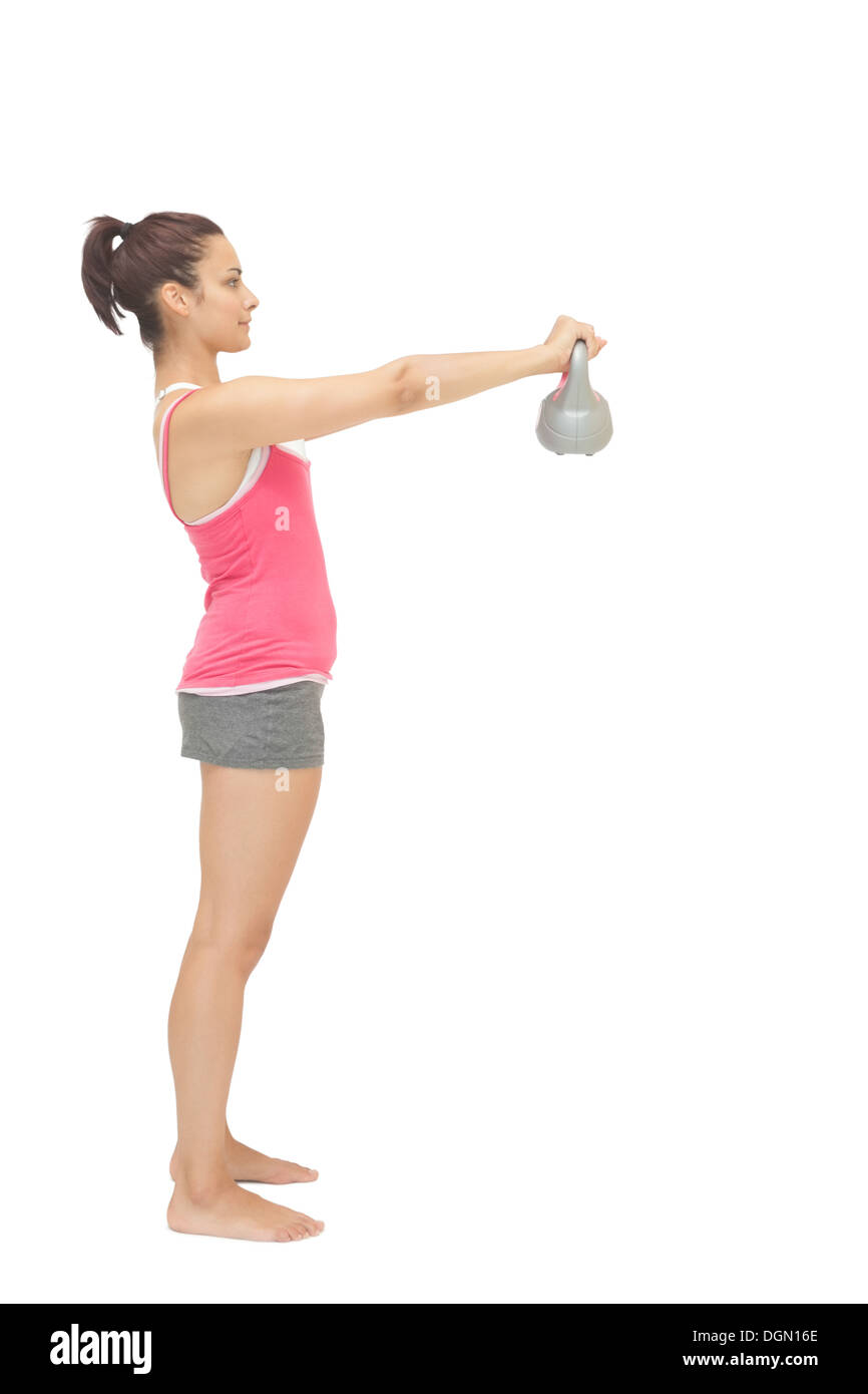 Attractive toned brunette holding grey kettlebell Stock Photo