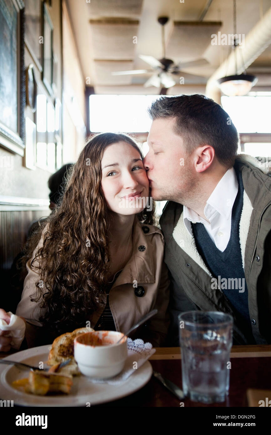 Couple kissing in restaurant Stock Photo