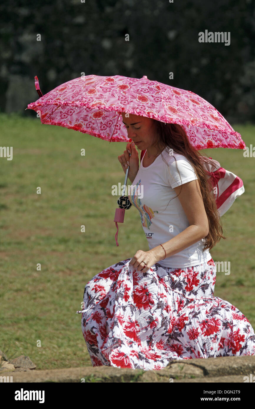 LADY WITH PINK PARASOL & FLORAL DRESS GALLE SRI LANKA 17 March 2013 Stock Photo